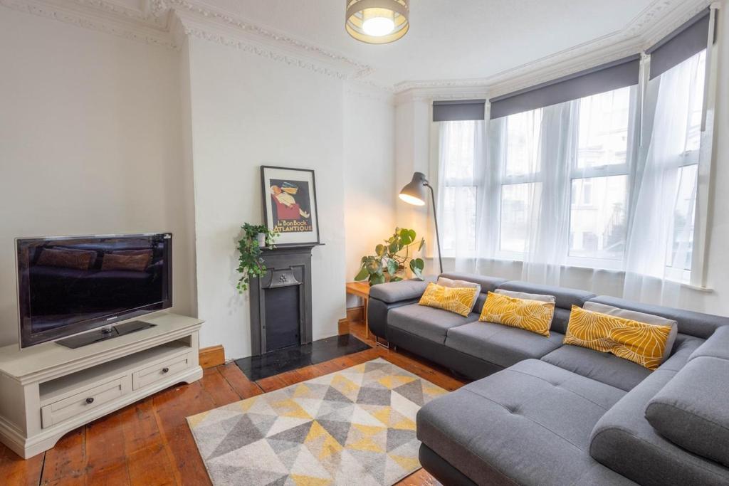 a living room with a couch and a flat screen tv at Large House, Garden, 3 Bedrooms in Bristol