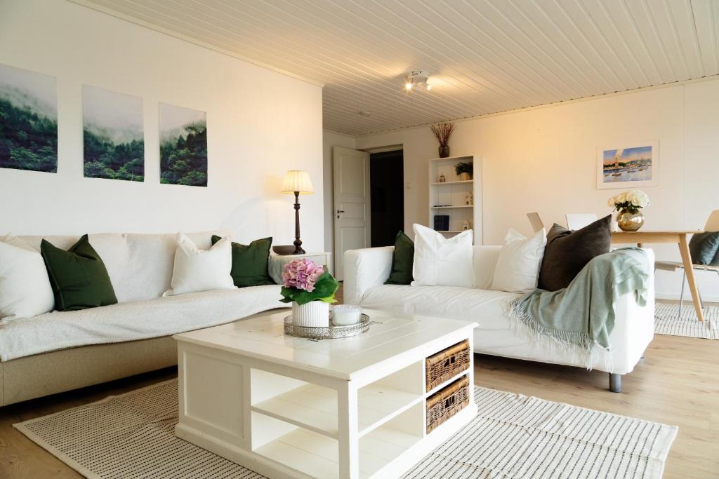 a living room with two white couches and a coffee table at Apartment with exceptional view in Ålesund