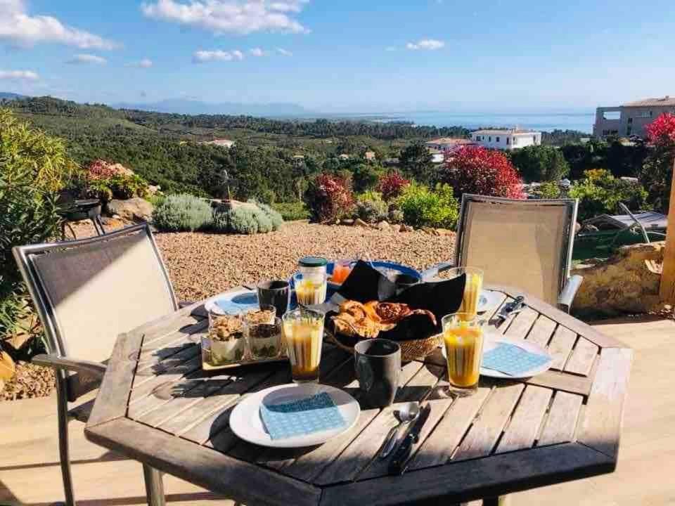 - une table de pique-nique avec de la nourriture et des boissons sur la terrasse dans l'établissement Magnifique appartement vue mer et montagne à Solenzara Corse, à Sari-Solenzara