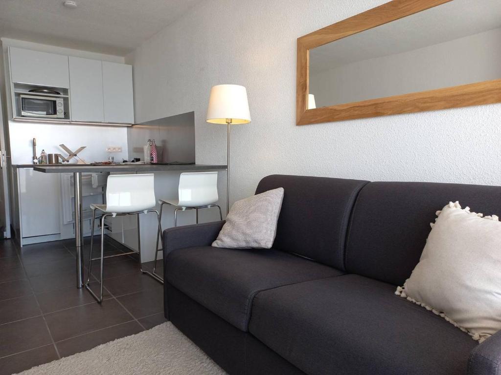 un salon avec un canapé et une cuisine dans l'établissement Studio Cabine 4 pers, parking privé, direct plage - FR-1-559-37, à Palavas-les-Flots