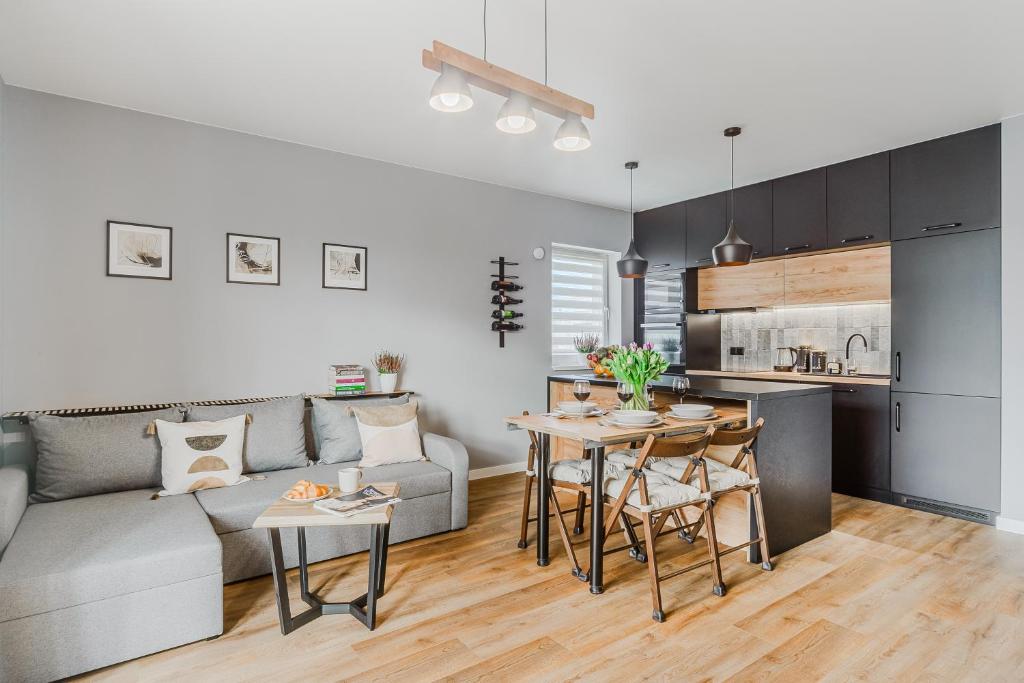 a living room with a couch and a table at Lumina luxury 3-rooms apartments with parking in Łódź