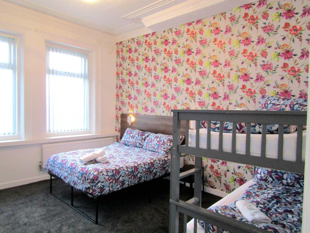 a bedroom with two bunk beds and a floral wallpaper at Belroy Hotel in Blackpool