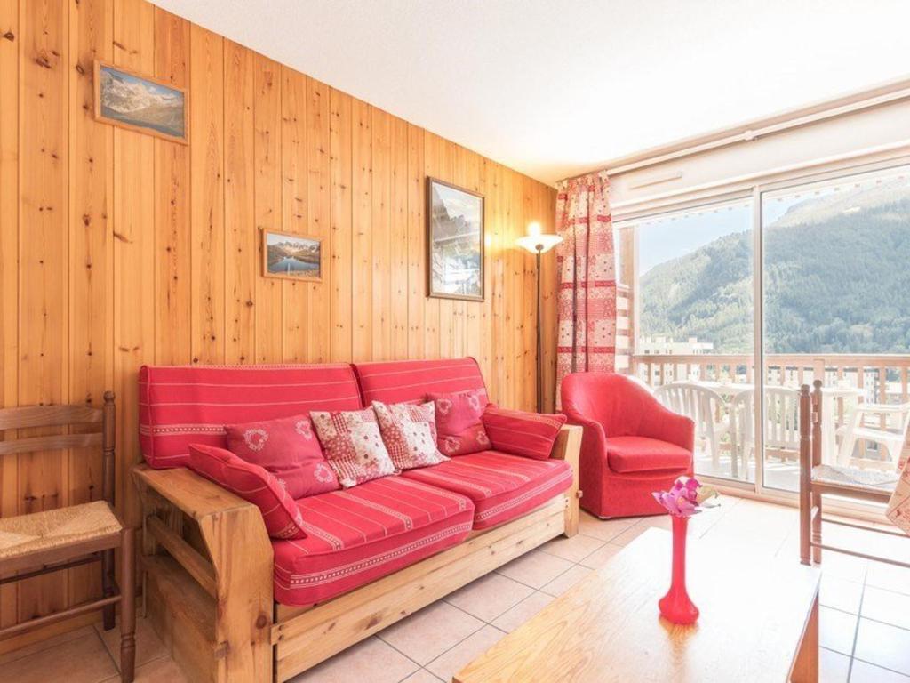 - un salon avec un canapé rouge et une chaise dans l'établissement Duplex cosy 6 pers. à Serre-Chevalier, Chantemerle - Balcon, Garage, Proche pistes - FR-1-330E-21, à Saint-Chaffrey