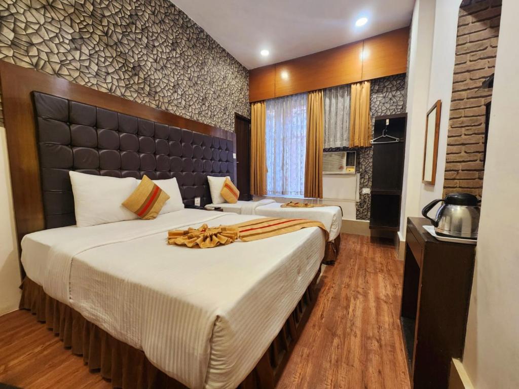 a hotel room with two beds in a room at Hotel Raunak in Kolkata