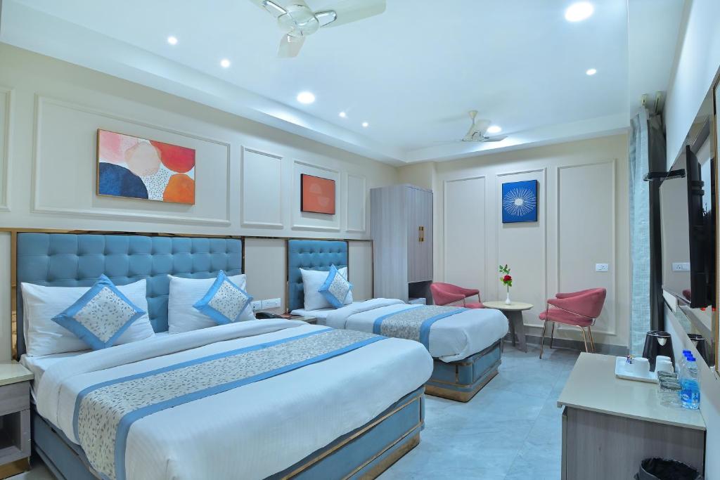 ニューデリーにあるHotel Sapphire House - 3 Mins Walk from Metro and 5 Mins from Rail Stationのベッド2台と机があるホテルの部屋