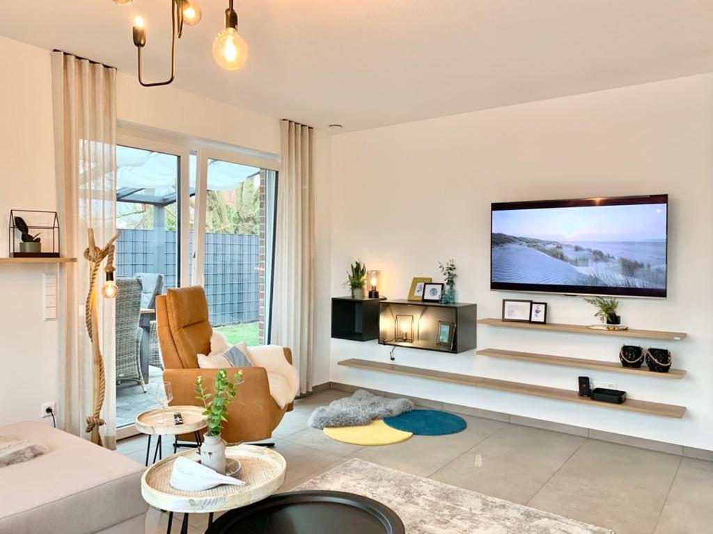 a living room with a flat screen tv on a wall at Traumhaus am See und Küste für die ganze Familie in Wangerland