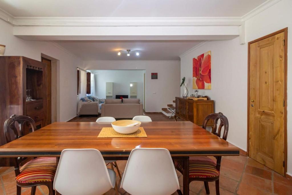 a dining room with a wooden table and chairs at Casa David Duplex in Olhão