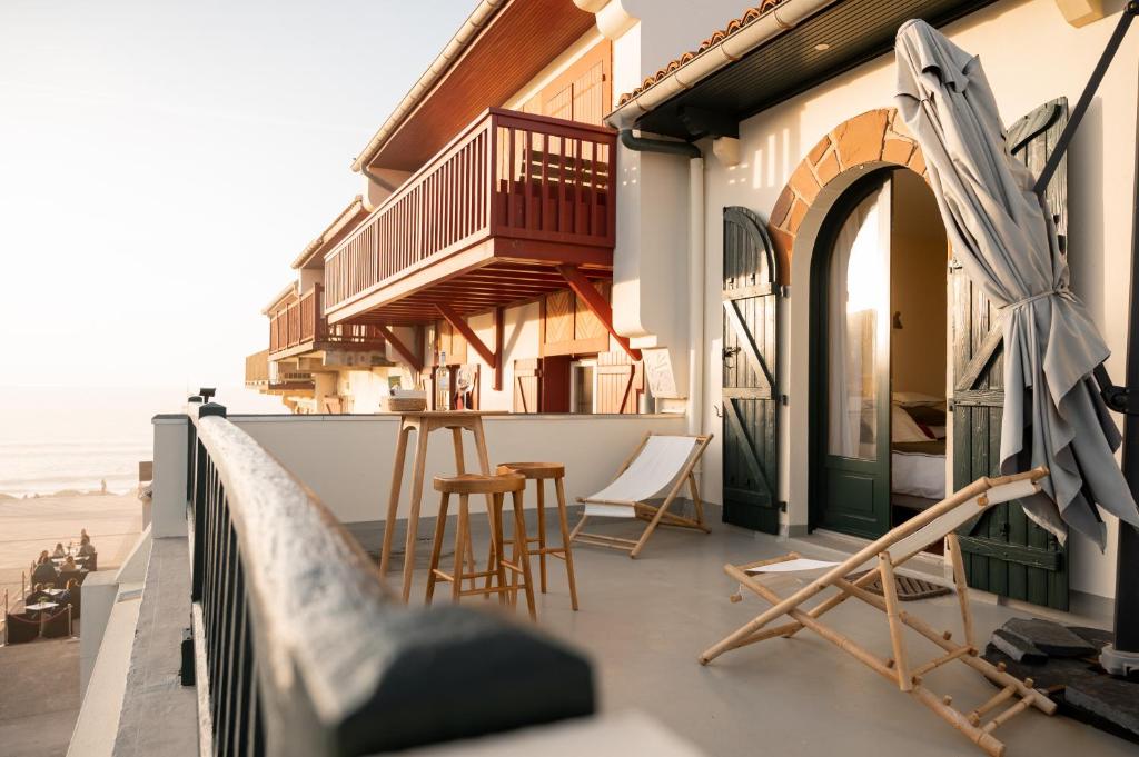 - un balcon d'une maison avec des chaises et des tables dans l'établissement Les Basques, Vue et Acces directe à la plage, immense terrasse, place des landais Hossegor, quartier très animé, idéal pour un séjour entre amis, à Soorts-Hossegor