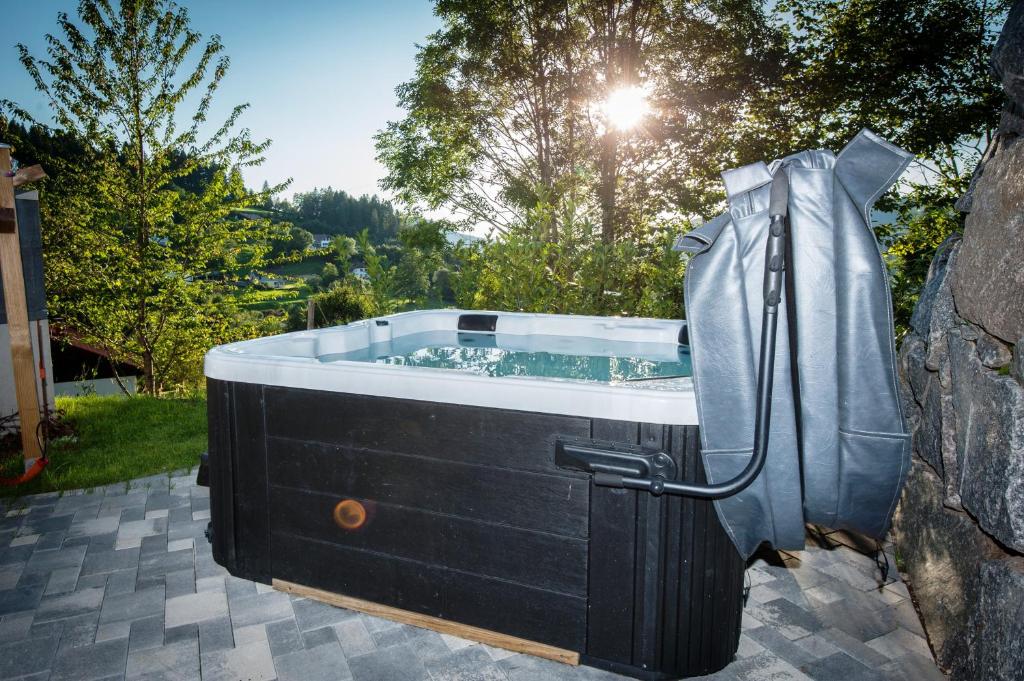 a bath tub in a yard with the sun shining at Chalet LES BICHES LUCY in Gérardmer