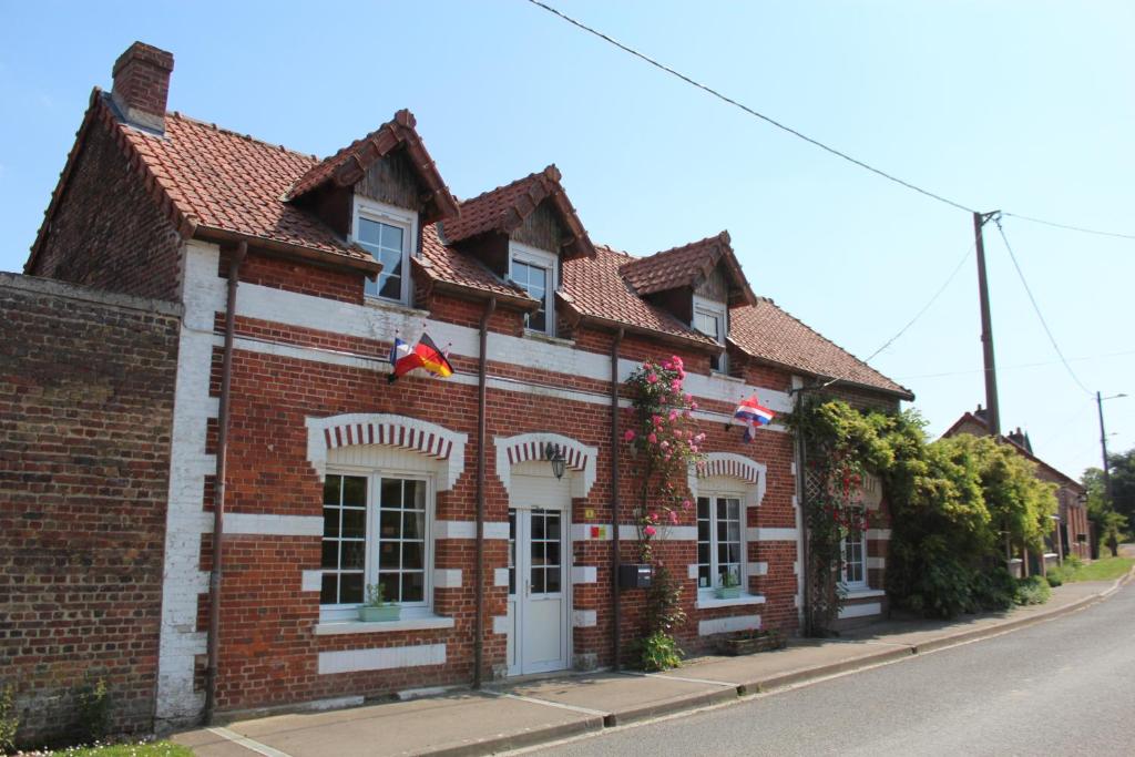 ceglany budynek z flagami na ulicy w obiekcie 14-18 Somme Chambres w mieście Beaucourt-sur-lʼAncre