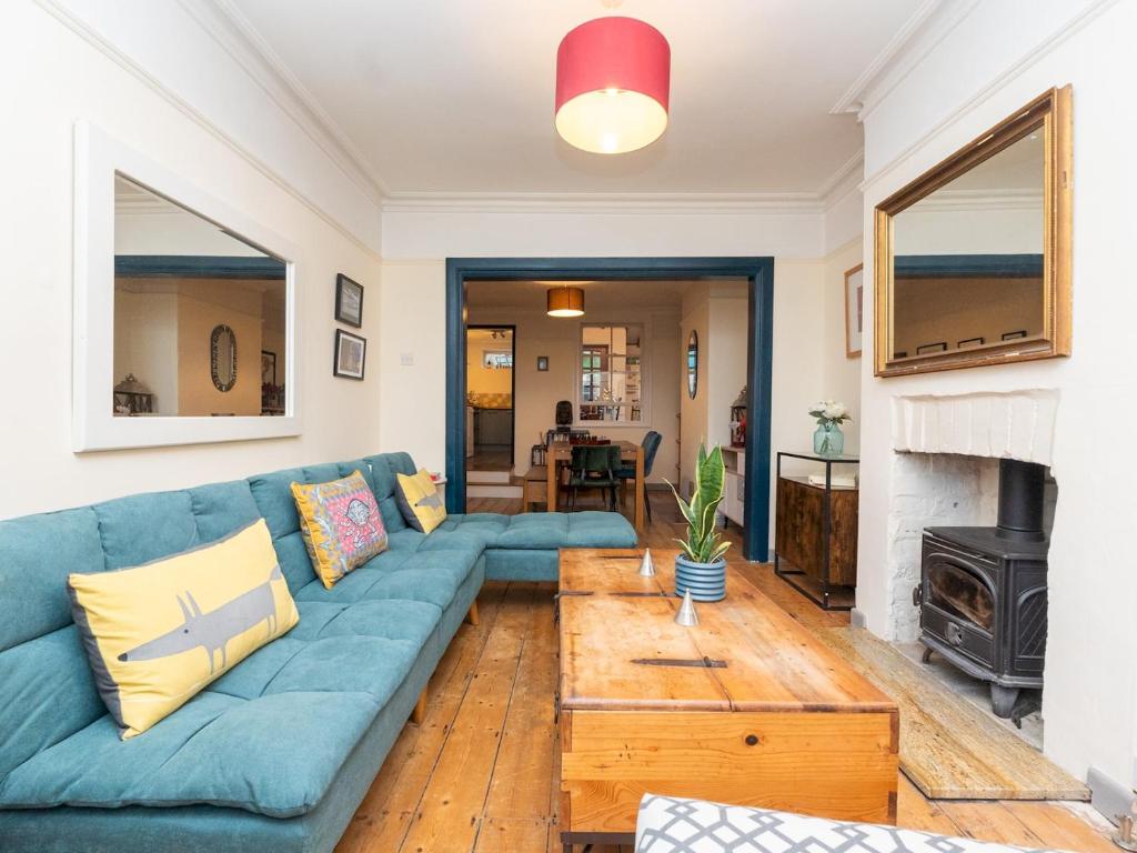 a living room with a blue couch and a fireplace at Spacious one bed house with parking - Pass the Keys in Bath
