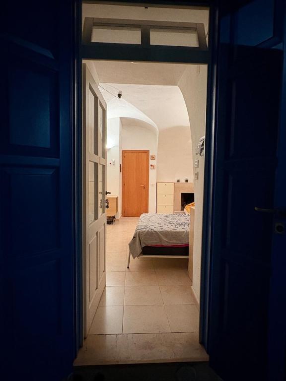 a dark room with a bed and an open door at Loft Incantevole in Peschici