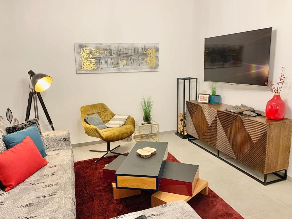 a living room with a couch and a tv at Neues Ferienhaus für Familien mit Garten und Sauna in Butjadingen