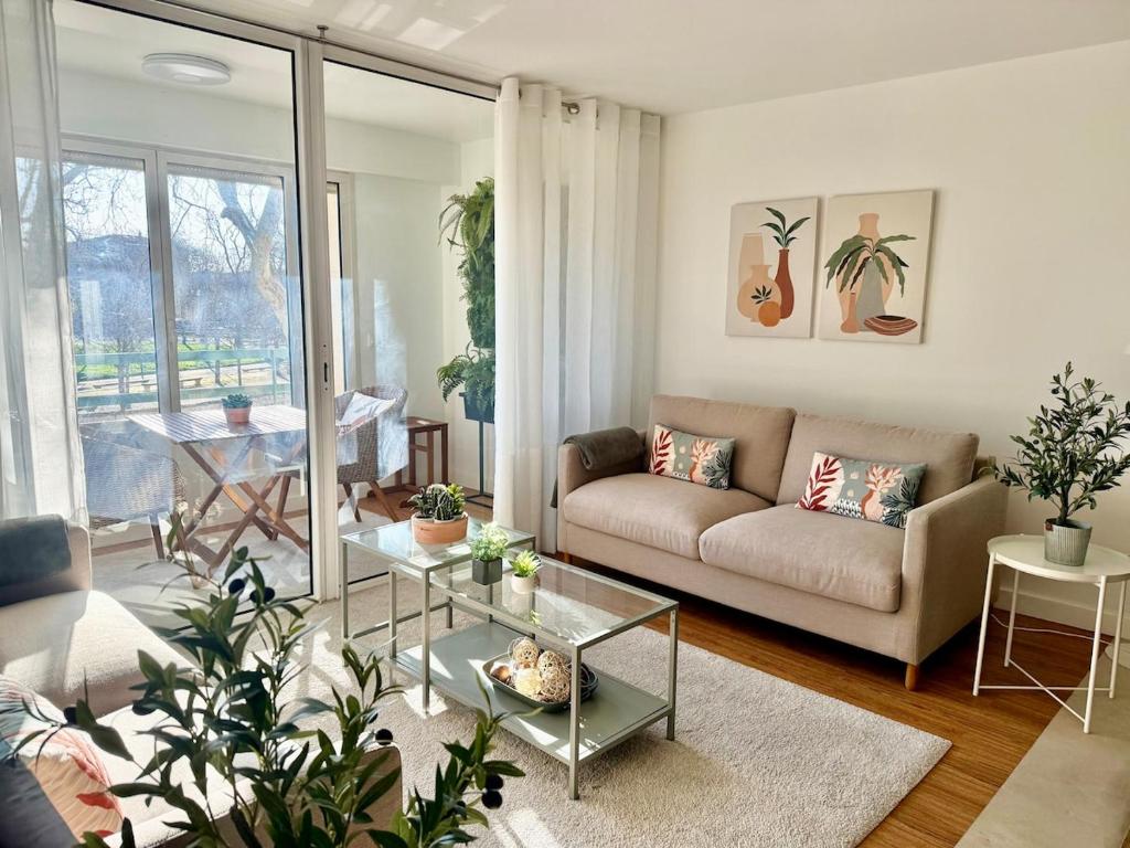 un salon avec un canapé et une table dans l'établissement Le Dandy de la Fontaine climatisation et garage, à Nîmes