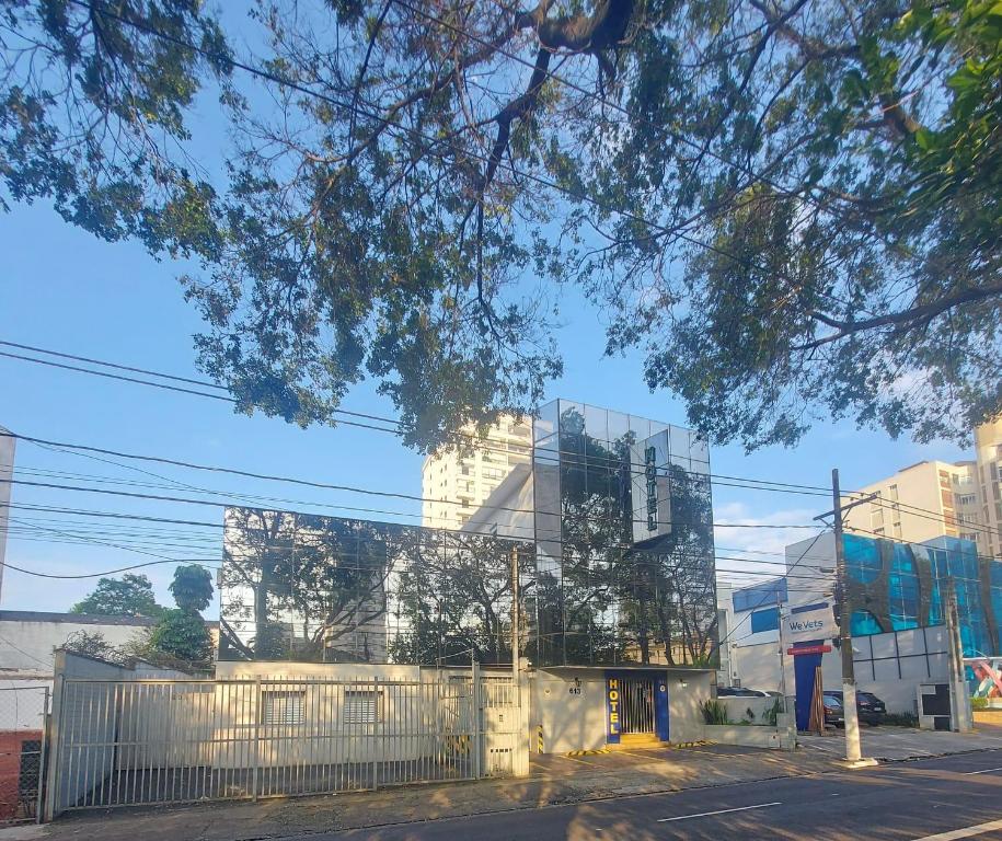 a glass building with a fence in front of it at Hotel Mooca in São Paulo