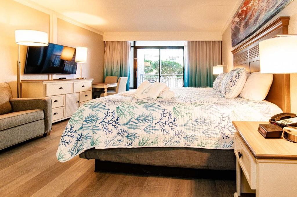 マートルビーチにあるTropical Suite at Oceanfront Resort w Lazy Riverのベッドとテレビがあるホテルの部屋