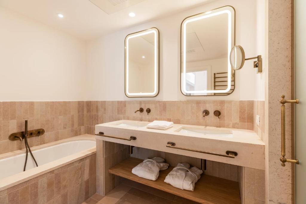 a bathroom with a sink and a tub and a mirror at Ostuni a Mare in Ostuni