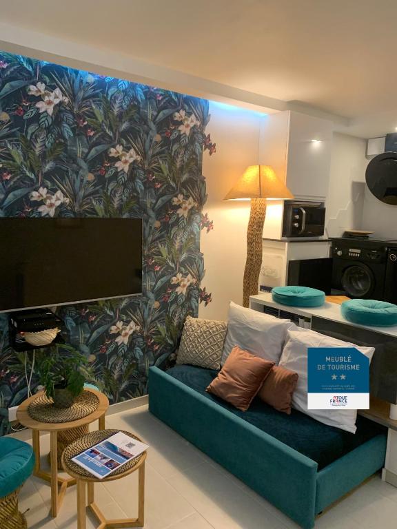 un salon avec un canapé et une télévision dans l'établissement L'îlot Bornala, à Nice