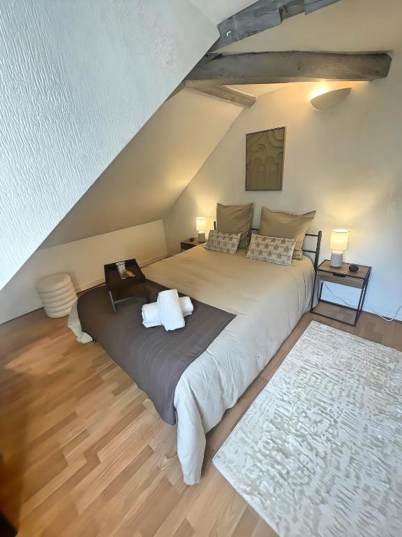 a bedroom with a large bed in a attic at La Mansarde - Cœur Historique, Charme et Confort in Brive-la-Gaillarde