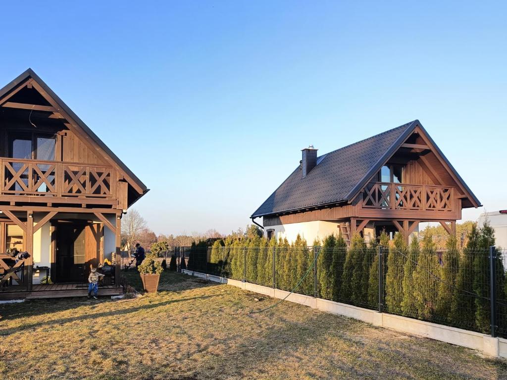 una casa con una valla delante en Wdzydzka Chatka, en Wdzydze Tucholskie