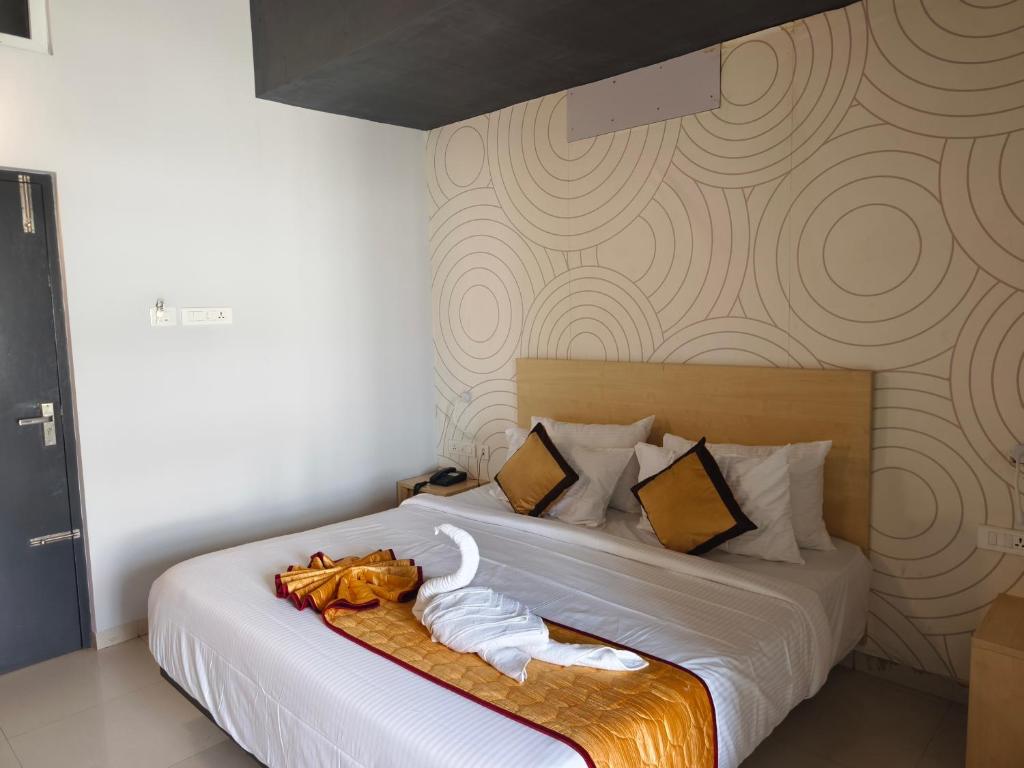 Un dormitorio con una cama con toallas. en Skyry Residency Tidel Park, en Coimbatore