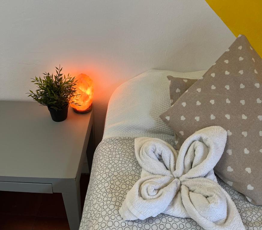 Una cama con toallas junto a una mesa. en Roomin Hostel, en Salamanca