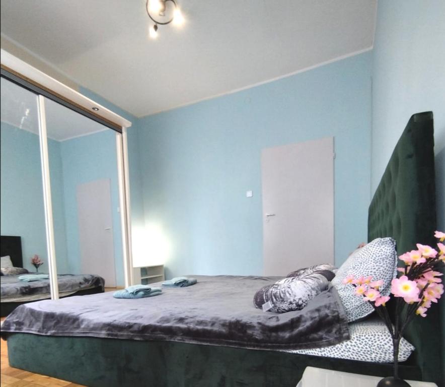 a bedroom with blue walls and a bed with a chair at By the beach,by Grand Hotel, Central,Molo in Sopot