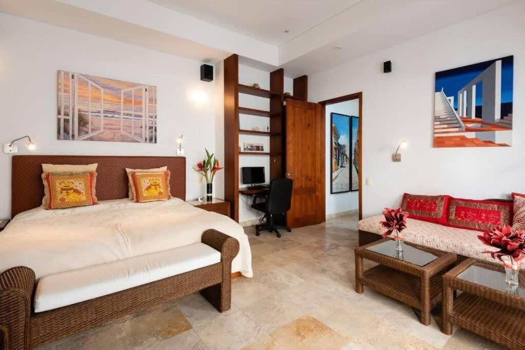una camera da letto con un letto grande e una scrivania di Luxury Apartment Private Pool & Rooftop Jacuzzi a Cartagena de Indias