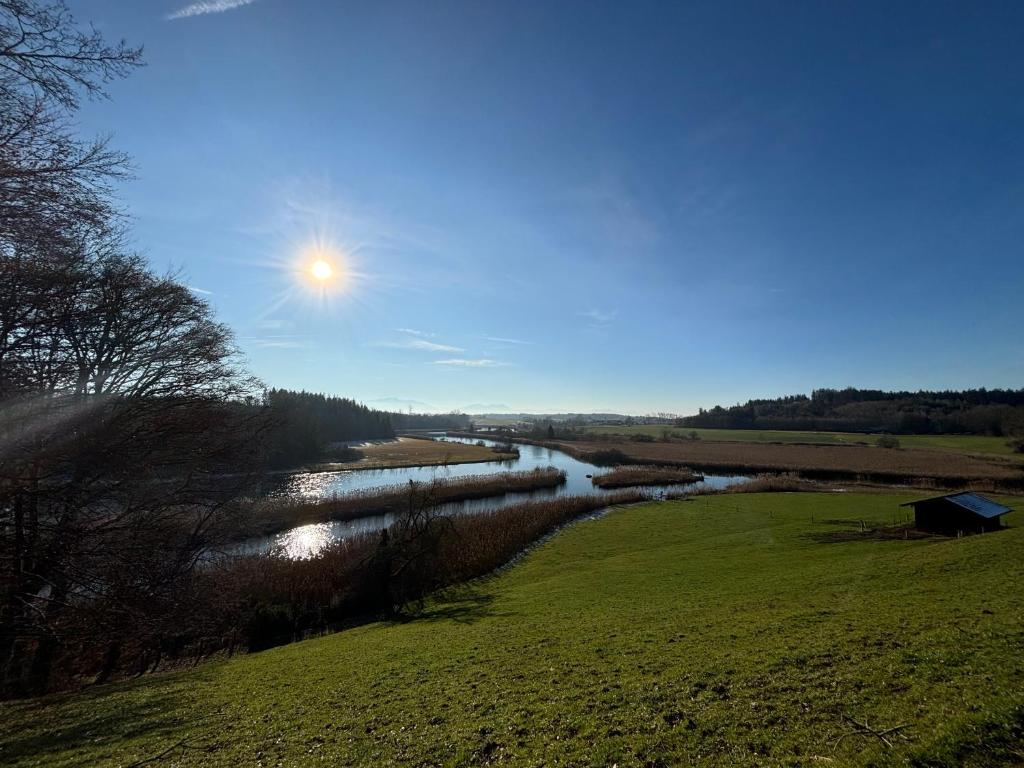 a view of a river with the sun in the sky at Alz-Apartment in Seeon-Seebruck