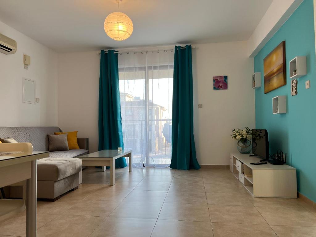 a living room with a couch and a large window at AFRODITI APARTMENTs in Perivolia