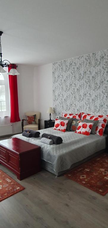 a bedroom with a large bed with red pillows at Virágos Birtok és Vendégház in Villány
