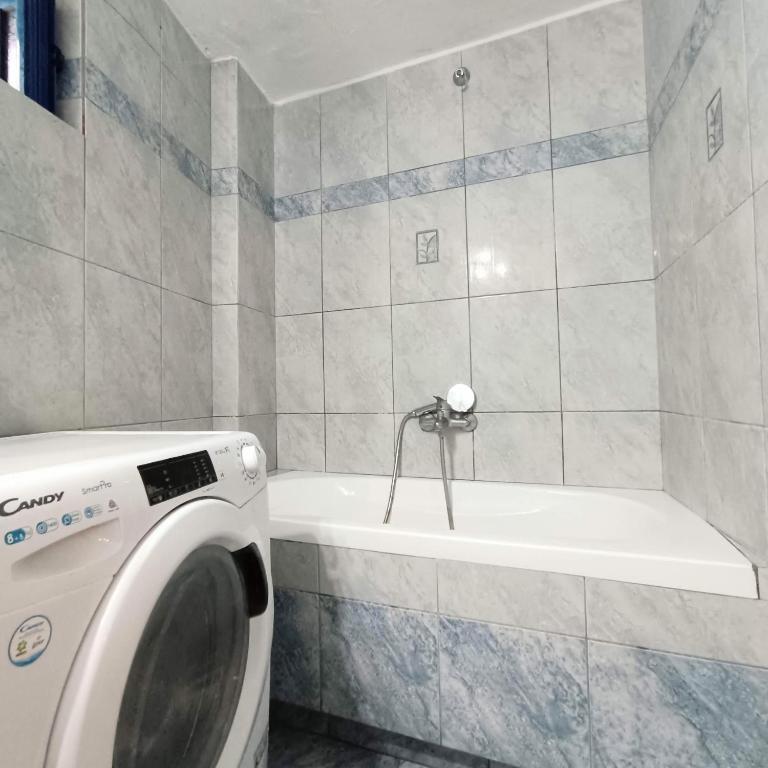 a bathroom with a washing machine and a bath tub at Perno in Serifos Chora