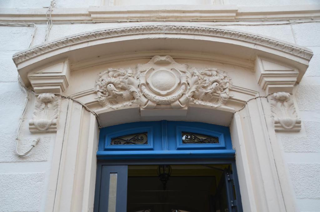een deuropening van een gebouw met een blauwe deur bij Hotel de France in Narbonne