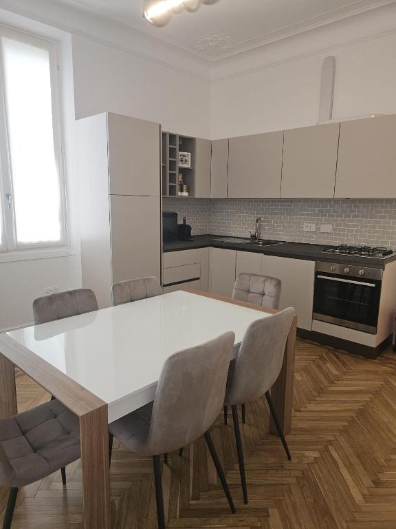 サンレモにあるSanremo Prestige Apartmentのキッチン(白いテーブル、椅子付)