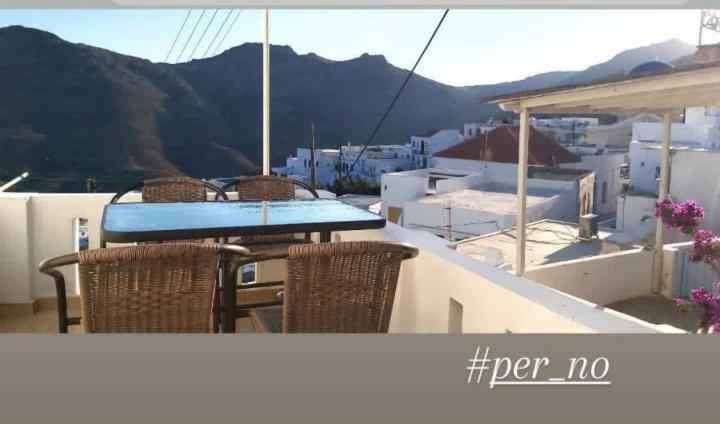 a table and chairs on a balcony with a view at Perno in Serifos Chora