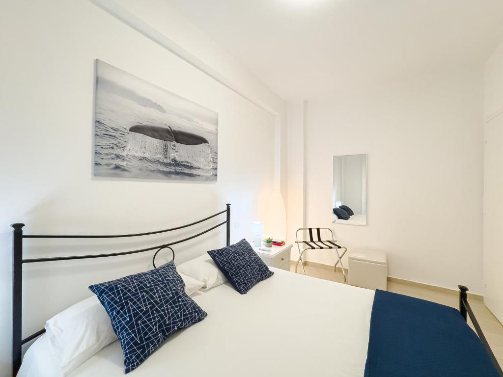 a bedroom with a bed with blue and white pillows at DanysHome Circe davanti al mare in Terracina