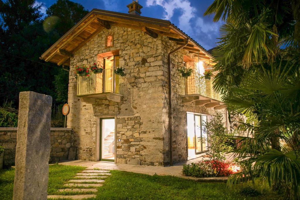 a stone house with a balcony and a window at Ca da la Butina in Mergozzo