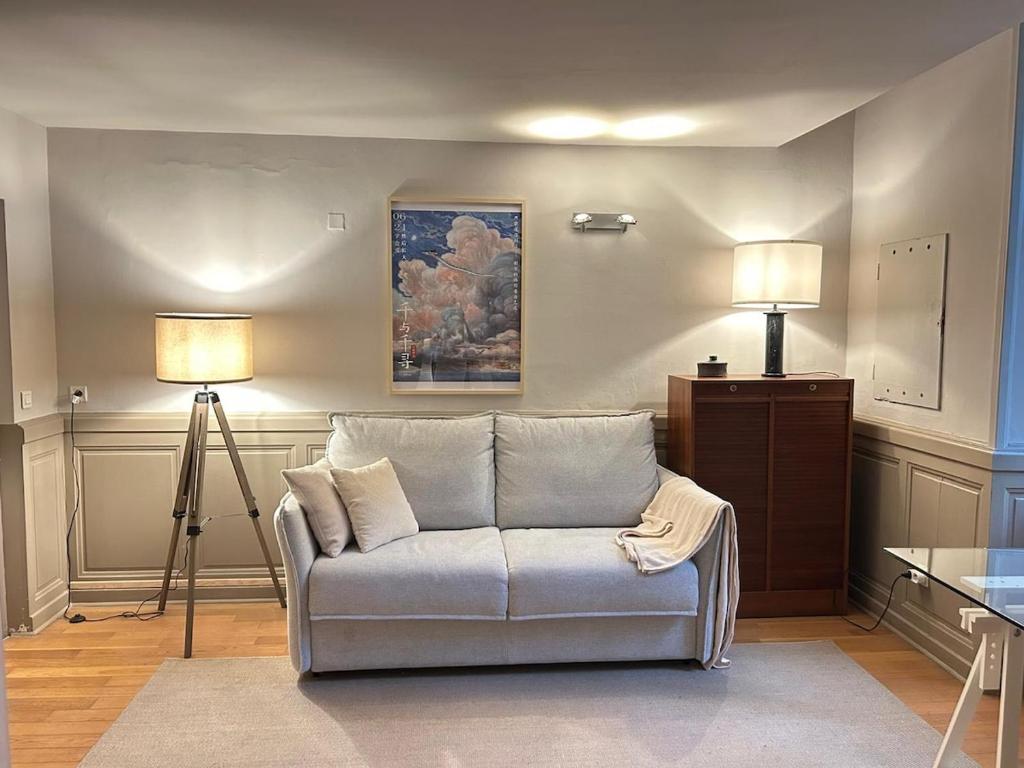 un salon avec un canapé et une lampe dans l'établissement Elégant studio Avignon centre, à Avignon