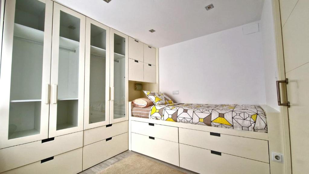 a bedroom with white cabinets and a bed at Piso Mariña in Marín