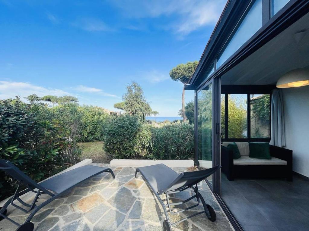 Cette maison dispose d'une terrasse avec des chaises et un canapé. dans l'établissement Appartement Solane 23 Lumio, à Lumio