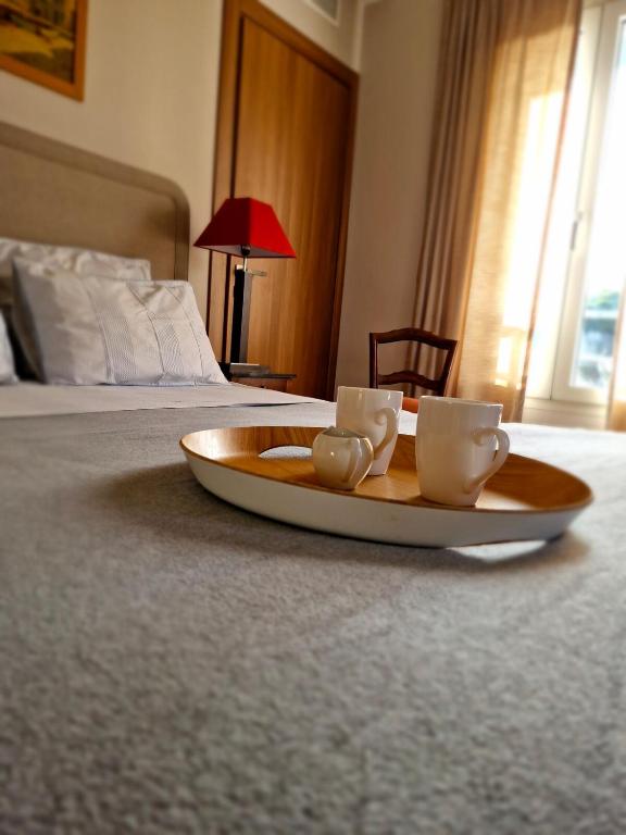 - un plateau avec 2 tasses à café sur le lit dans l'établissement Grand 3 chambres quartier Pinède Juan, à Antibes