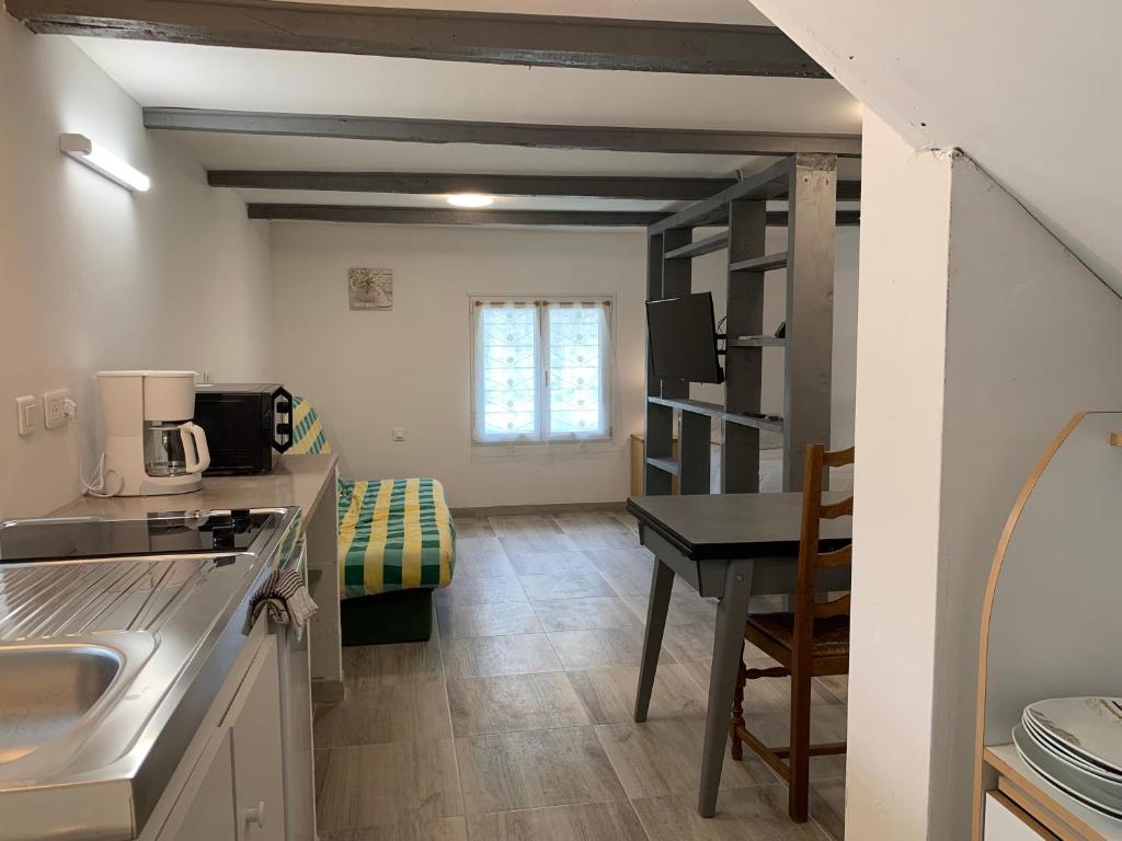- une cuisine avec un évier et un bureau dans la chambre dans l'établissement Gîte des champs, à Montélimar
