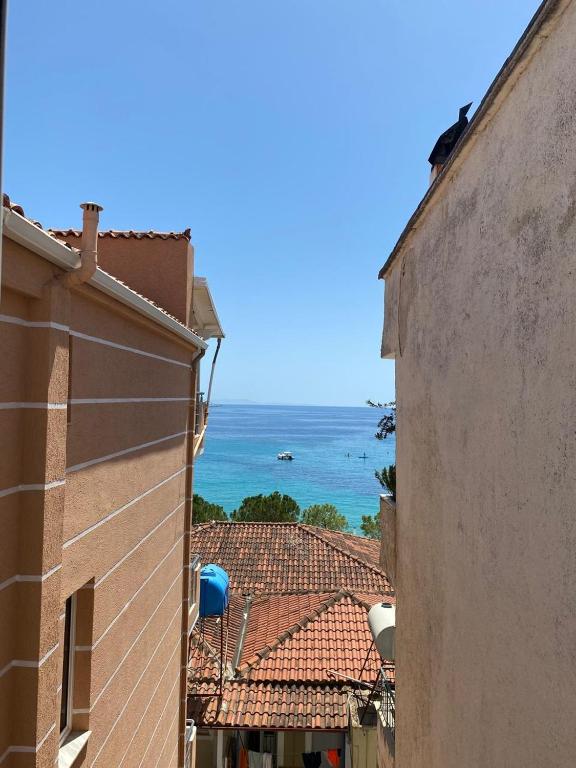 a view of the ocean from between two buildings at Himara City-Center Apartment in Himare