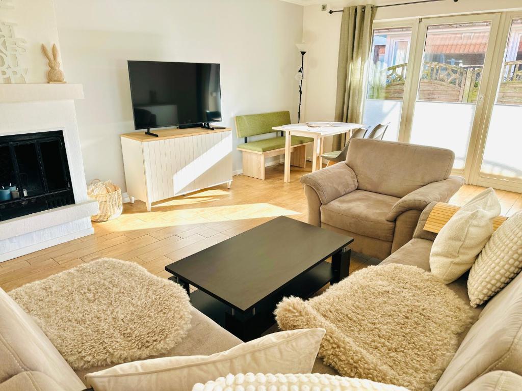 Una sala de estar con un sofá y un televisor. en Meer-Lust-Sylt family and friends - 2025 refreshed, en Westerland