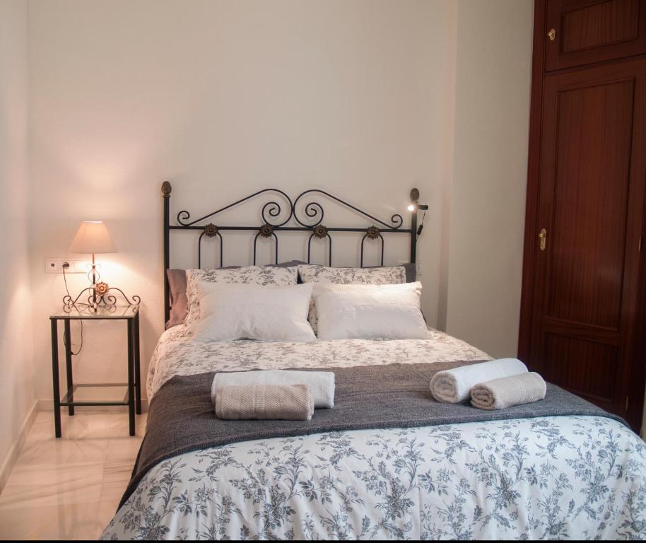 1 dormitorio con 1 cama con 2 toallas en Fan Flat Rosaleda, en Málaga