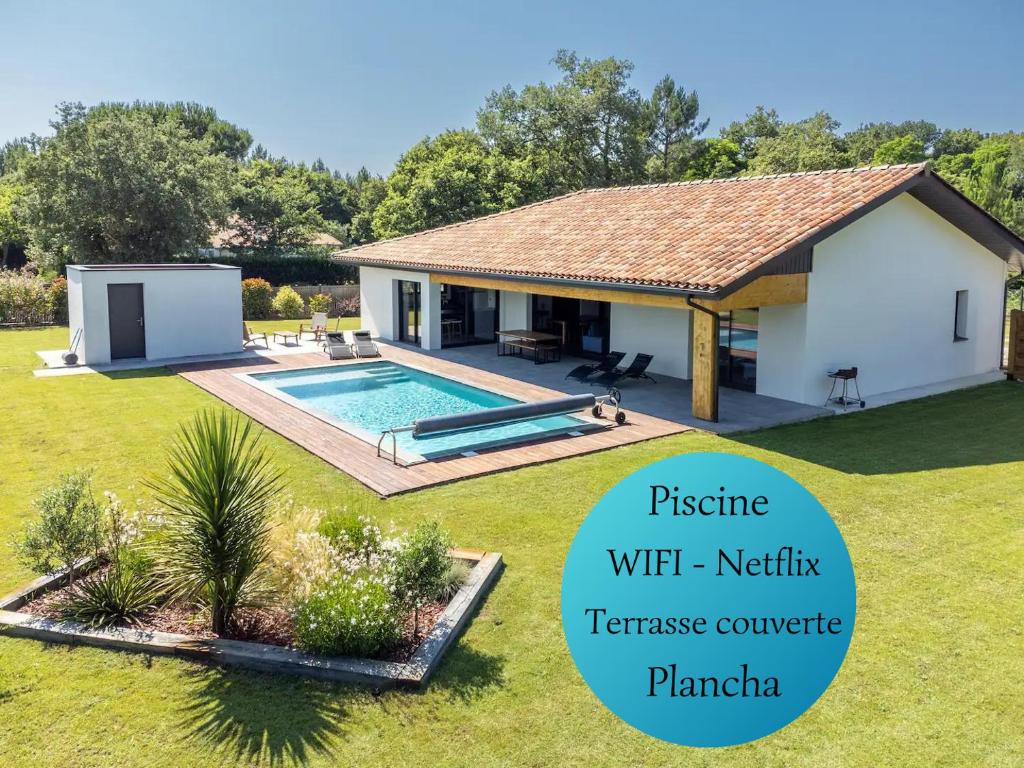une villa avec une piscine dans un jardin dans l'établissement Superbe Villa au calme avec piscine, à Pontenx-les-Forges