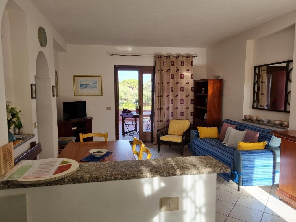 een keuken en woonkamer met een tafel en een bank bij Le Canne - Appartamento "Luna" in San Teodoro