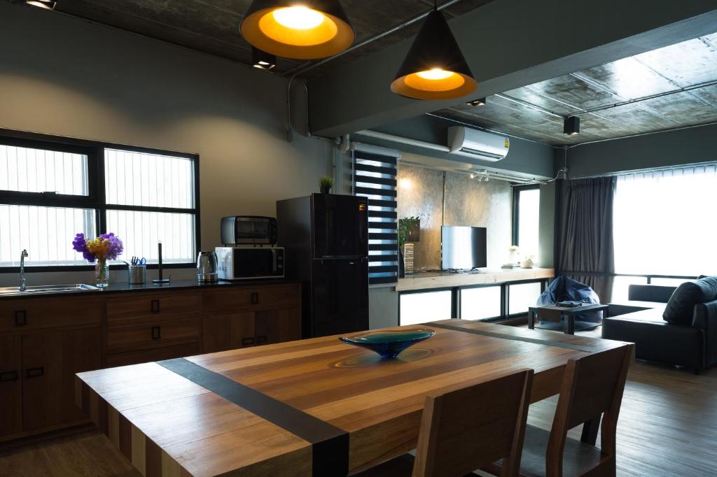 a kitchen and living room with a wooden table at Nord Studio in Chiang Mai