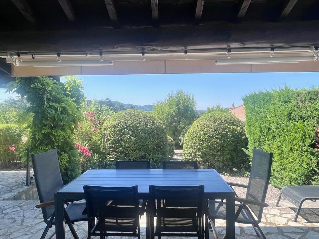 une table et des chaises bleues sur une terrasse dans l'établissement Maison du Ventoux, à Mormoiron