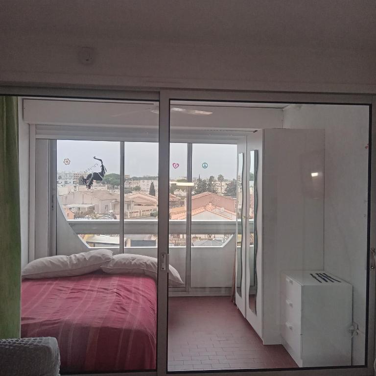 - une chambre avec un lit et une vue sur la ville dans l'établissement studio, au Grau-du-Roi
